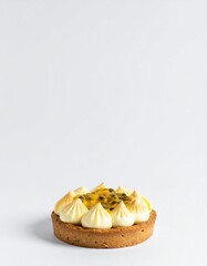 Decadent passion fruit tart with creamy meringue swirls and fresh fruit topping on white background