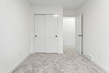 White bedroom with a white closet and a white door