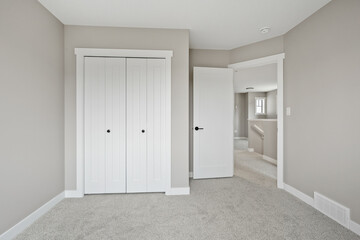 White bedroom with a white door and white closet