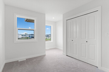 White bedroom with a window and a closet