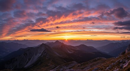 Naklejka premium Alpine mountain range at sunrise with dramatic sky