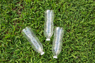 empty plastic water bottles lie in the grass