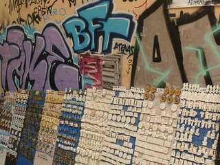 Magnets and statues of the Parthenon and other monuments exposed in a souvenir shop in Athens, in front of a graffiti wall