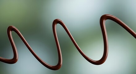 A smooth, dark chocolate drizzle forms a flowing wavy line against a soft, blurred green background.