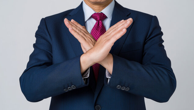 formal businessman refusing with X hand sign, assertive body language