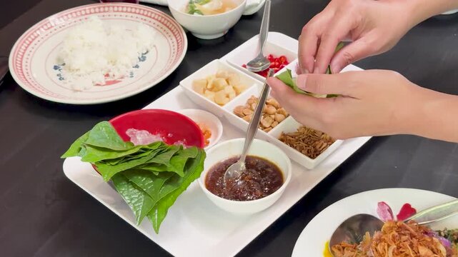 Assembling Miang Kham Savory Leaf Wraps at Table