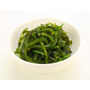 closeup heap of green laver ulva lactuca or sea lettuce seaweed cutout in white ceramic bowl 
