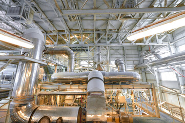 Chemical plant interior showcasing extensive pipelines and conveyors for industrial processing and material handling operations