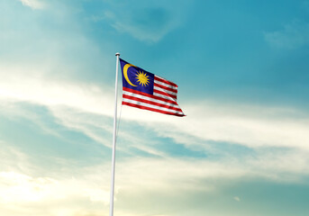 Malaysia flag is waving on a tall flagpole among the clouds. Malaysia national flag for independence day.