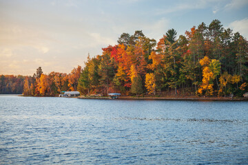 Shoreline with boats and trees in brilliant color during autumn in northern Minnesota