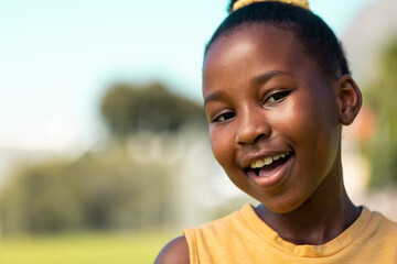 African American girl smiles brightly outdoors with copy space