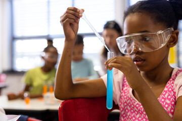 girl conducts a science experiment in a school classroom