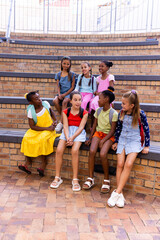 Diverse group of girls chatting on school bleachers