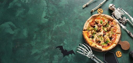 Tasty Halloween pizza and decorations on green background with space for text