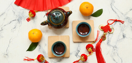 Fan with tangerines, cups of tea and Chinese symbols on grunge white background. New Year celebration
