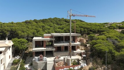 Luxury home under construction with crane on hillside in Majorca, Spain