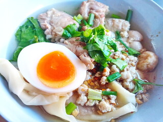 Thai noodle soup with pork, dumpling, and soft-boiled egg