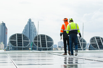 Electrical engineers inspecting and installing a solar panels on the building rooftop.