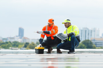 Electrical engineers inspecting and installing a solar panels on the building rooftop.