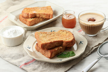 French Brioche Toast with Powdered Sugar, Honey, and Mint Leaf on Ceramic Plate