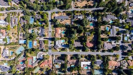 Drone aerial shot of upscale hillside homes surrounded by trees and private pools in a quiet luxury neighbourhood near San Jose, California