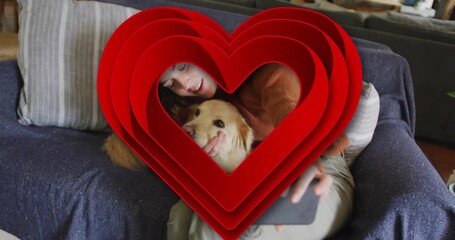 Red heart receding reveal woman cradling dog on sofa before raising phone for technology selfie - Powered by Adobe