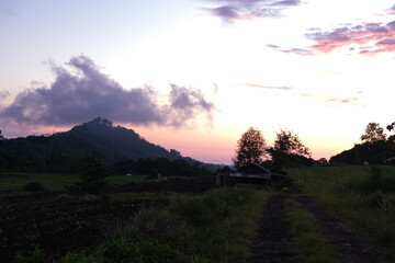 A breathtaking sunrise over a tranquil countryside landscape, with golden light illuminating the rolling hills and meadows