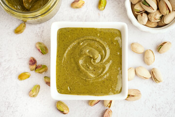 Tasty pistachio paste in bowl on white background