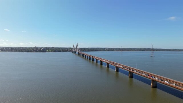 Drone video of cars crossing the San Roque Gonz&aacute;lez Bridge over the Paran&aacute; River on a sunny day.