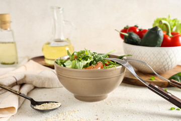 Bowl of fresh vegetable salad with tomato on white background