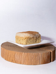 tres leches sponge cake slice on a wooden board on a white background