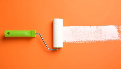 Obraz premium A paint roller leaves a trail of white paint on an orange surface.