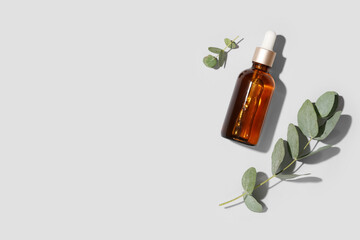 Bottle of eucalyptus essential oil on grey background