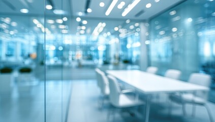 Blurred view of a modern, bright office space with glass partitions and a conference table