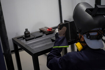 Welder performing Tungsten Inert Gas welding process (TIG) on stainless steel. TIG welding uses the heat generated by an electric arc struck between a non-consumable tungsten electrode and the work