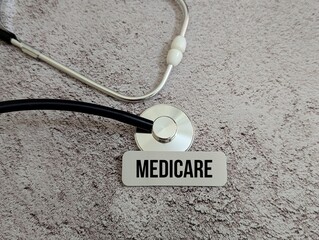 Stethoscope with Medicare sign on textured background, health insurance and medical care concept.