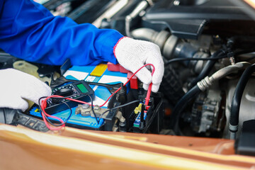 Auto mechanics check car engines with digital multimeters, test batteries and fuse boxes, and inspect electrical systems. Car service and maintenance.