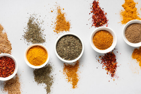 Composition with bowls of different spices on grey background