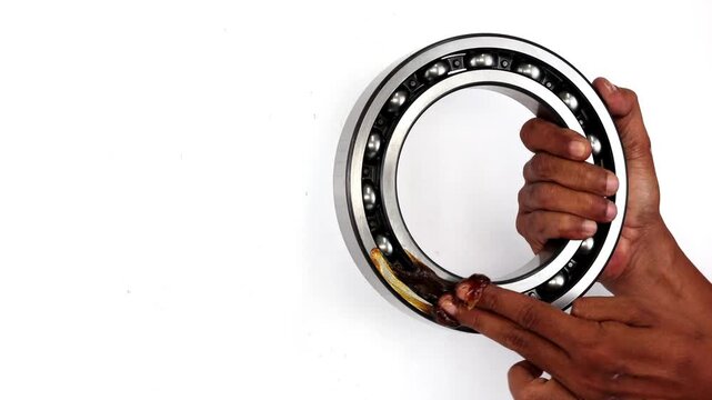 Male hand holding and applying grease to bearing isolated on white background.