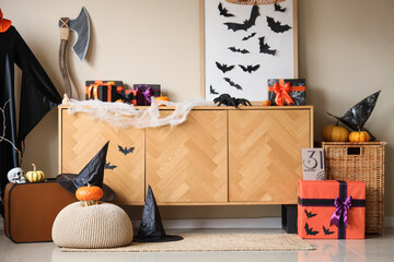 Interior of festive living room with wooden cabinet, Halloween decorations and gift boxes