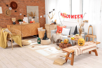 Interior of festive living room decorated for Halloween with sofa and pumpkins