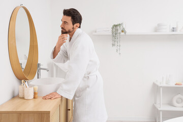 Morning of handsome man near mirror in bathroom
