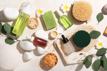 Obraz na płótnie Canvas Composition with bottles of cosmetic products, spa stones and sea salt on beige grunge background, closeup