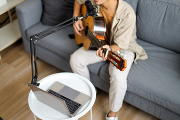 Overhead View Of Musician Playing Guitar And Singing Into Mic With Laptop