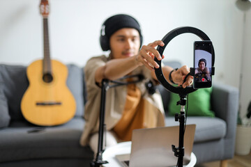 Young Asian Influencer Adjusting His Smartphone On Ring Light Preparing For Live Stream