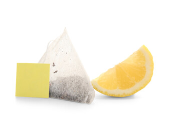 Piece of lemon with tea bag isolated on white background, closeup