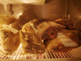 Aged marbled cheese stored on a white wire shelf inside a refrigerator at a fine steak restaurant in Bangkok, Thailand, showcasing gourmet food preparation.