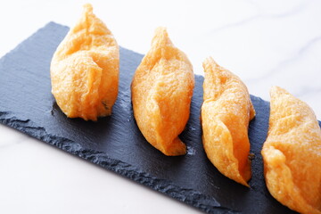 いなり寿司 - 甘辛く煮た油揚げに酢飯を詰めた稲荷寿司
