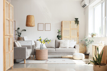 Interior of living room with comfortable sofas and table near white wall