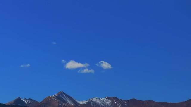 Opening shot Aspen Mount Snowmass Capitol Peak fall autumn sunny blue sky morning aerial drone Colorado White River National Forest valley snow dusting Rocky mountain peaks forward pan up pan down